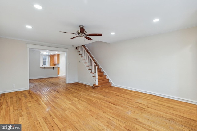 unfurnished living room featuring light hardwood / wood-style floors and ceiling fan with notable chandelier