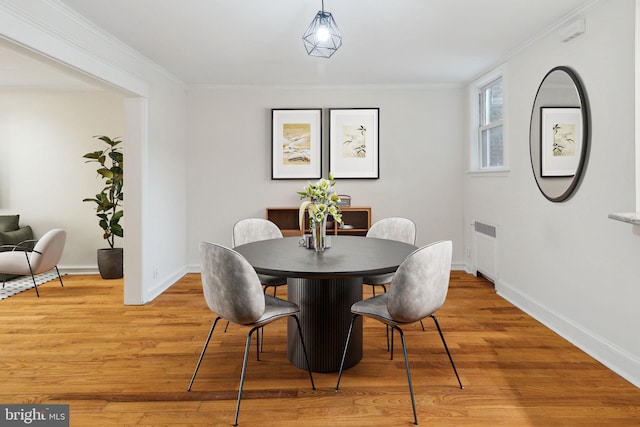 dining space featuring radiator, hardwood / wood-style flooring, and ornamental molding