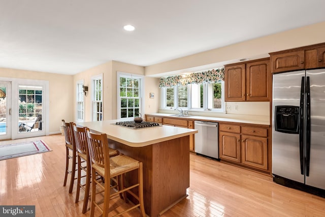 kitchen featuring appliances with stainless steel finishes, light hardwood / wood-style flooring, and a healthy amount of sunlight