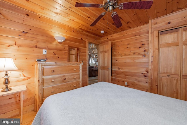 bedroom featuring carpet flooring, ceiling fan, wood ceiling, and wood walls