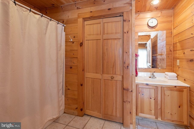 bathroom with tile patterned flooring, vanity, wooden walls, and wood ceiling