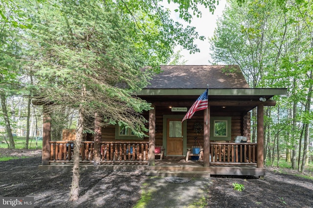 log cabin featuring covered porch