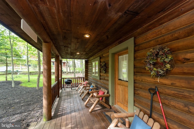 wooden terrace featuring area for grilling and covered porch