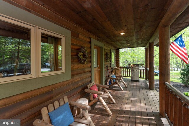 wooden deck with covered porch and grilling area