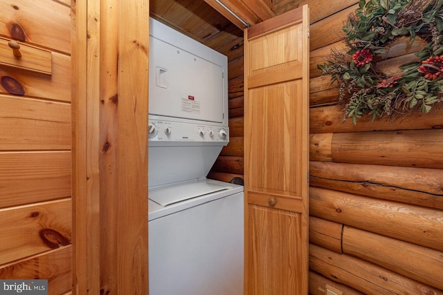 laundry area featuring log walls, stacked washer and dryer, and wood ceiling