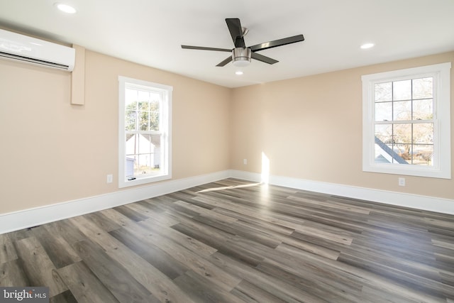 spare room featuring ceiling fan, dark wood-type flooring, and a wall unit AC