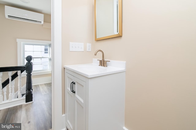 bathroom with wood-type flooring, vanity, and an AC wall unit