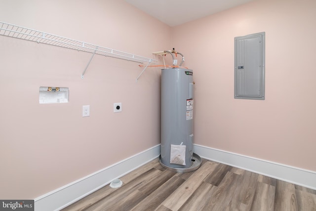 washroom featuring hardwood / wood-style floors, electric water heater, electric panel, hookup for a washing machine, and hookup for an electric dryer