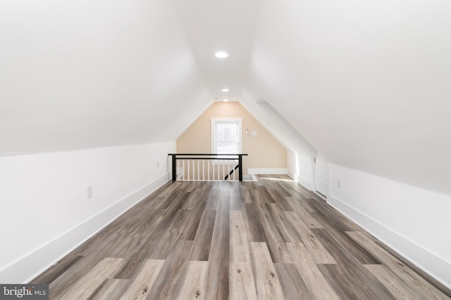 additional living space featuring hardwood / wood-style floors and vaulted ceiling