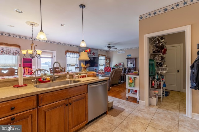 kitchen featuring ceiling fan with notable chandelier, sink, light tile patterned floors, decorative light fixtures, and dishwasher