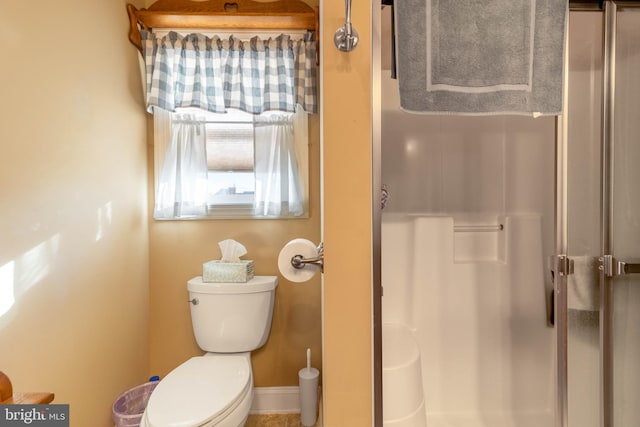 bathroom featuring walk in shower and toilet