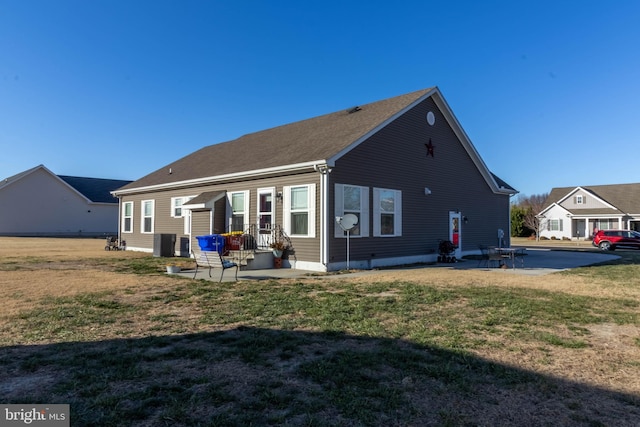 back of house with a yard and a patio