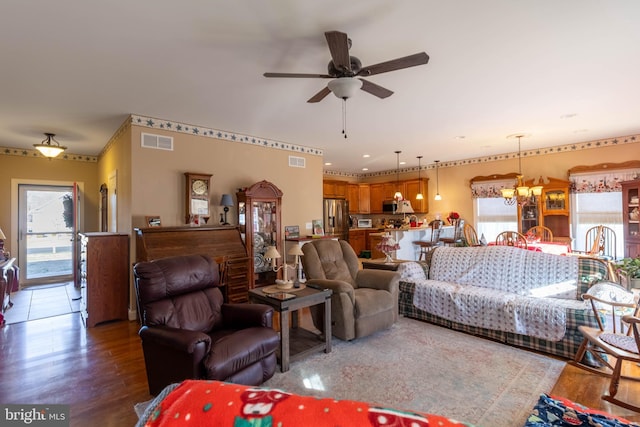 living room featuring hardwood / wood-style floors and ceiling fan with notable chandelier