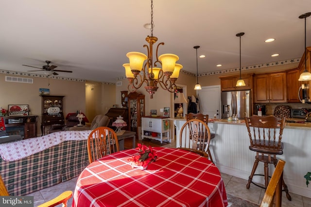 dining room with light tile patterned floors and ceiling fan with notable chandelier