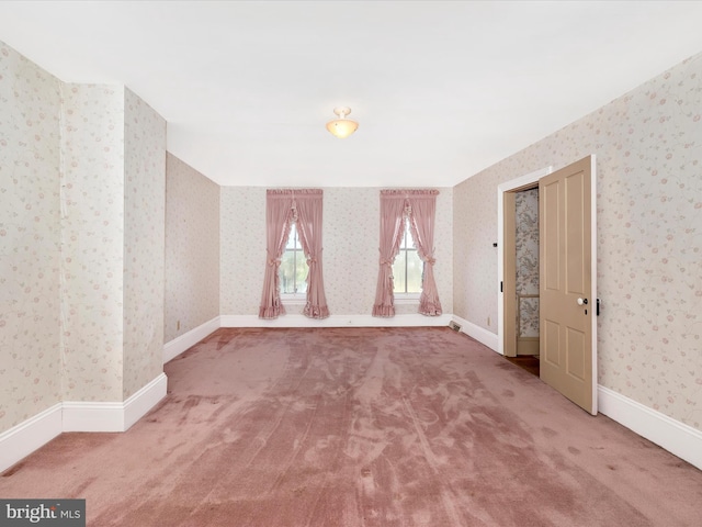 carpeted spare room with baseboards and wallpapered walls