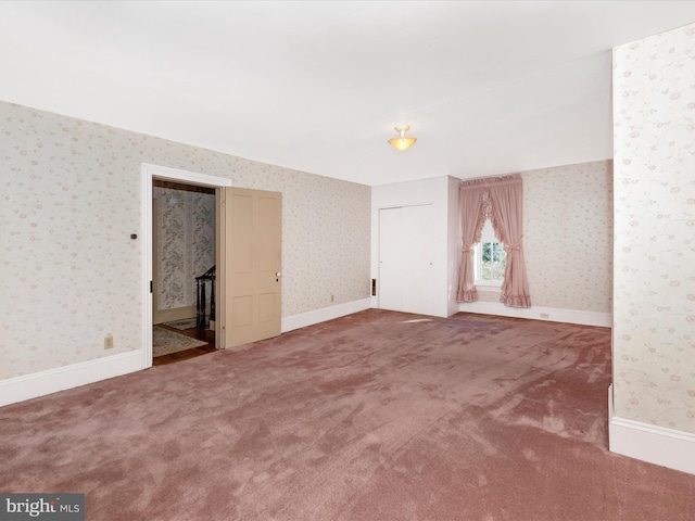 interior space featuring wallpapered walls and baseboards