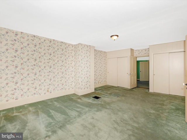 unfurnished room with wallpapered walls, baseboards, visible vents, and carpet flooring