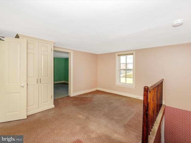 unfurnished bedroom featuring carpet and baseboards