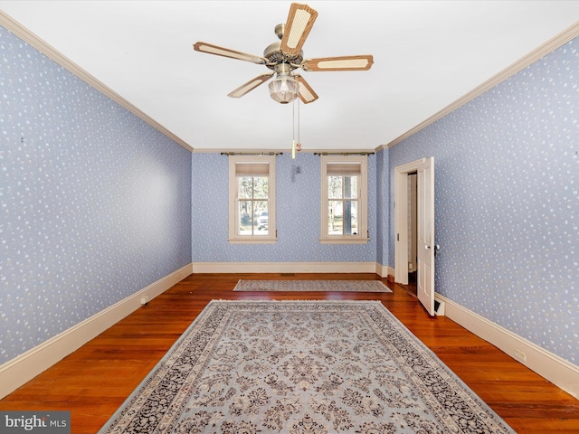 unfurnished room featuring wallpapered walls, baseboards, ornamental molding, and wood finished floors