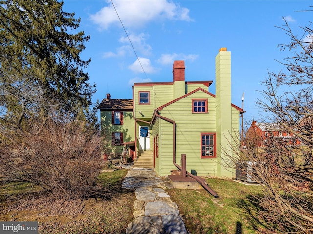 rear view of property featuring a chimney