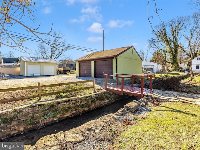 exterior space with a garage, an outdoor structure, and fence