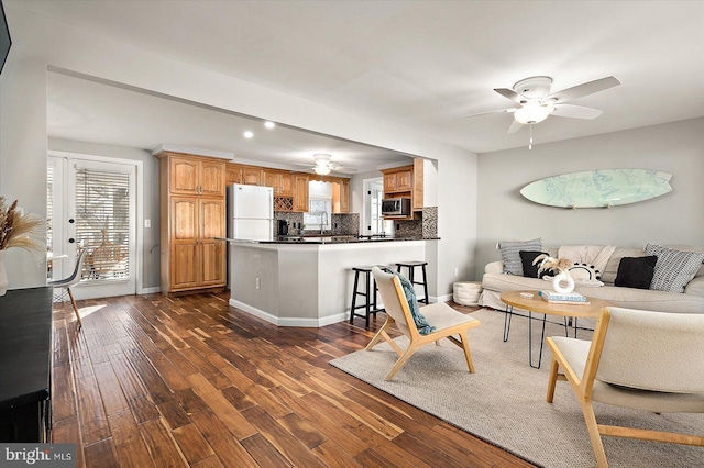 living room with dark hardwood / wood-style flooring and ceiling fan