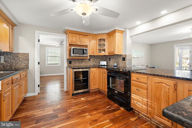 kitchen featuring backsplash, a healthy amount of sunlight, dark wood-type flooring, and black range with electric cooktop