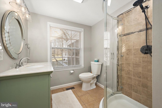 bathroom featuring tile patterned flooring, vanity, a shower with shower door, and toilet