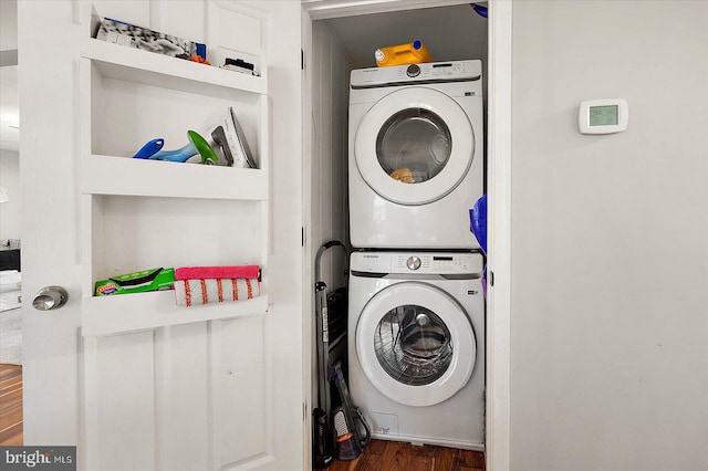 laundry room featuring dark hardwood / wood-style flooring and stacked washer / drying machine