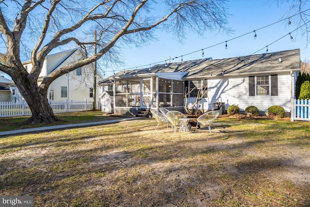 back of house featuring a sunroom and a lawn