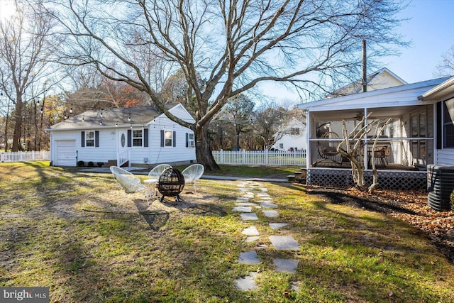 view of yard with a fire pit, a sunroom, and central AC unit