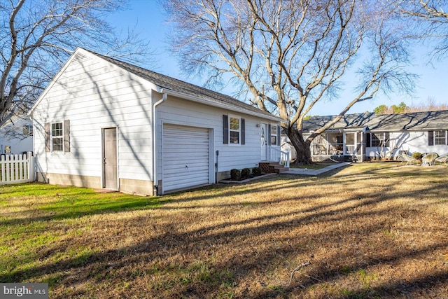 back of property with a yard and a garage