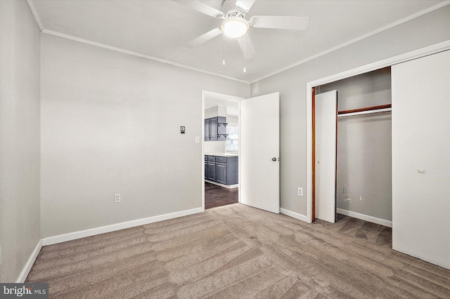 unfurnished bedroom with carpet flooring, a closet, ceiling fan, and crown molding