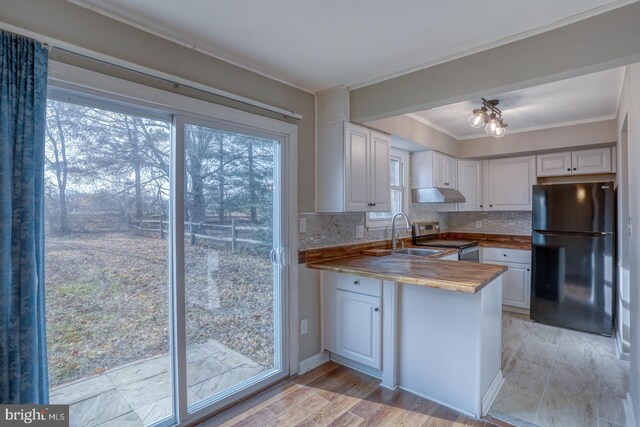 kitchen featuring decorative backsplash, white cabinetry, black refrigerator, and stainless steel electric range