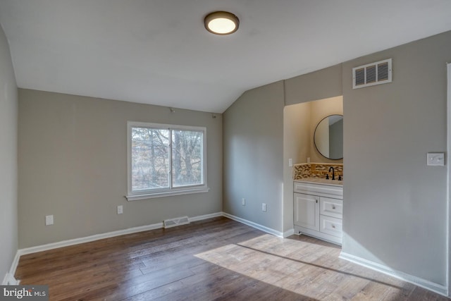 interior space featuring light hardwood / wood-style floors, sink, and vaulted ceiling