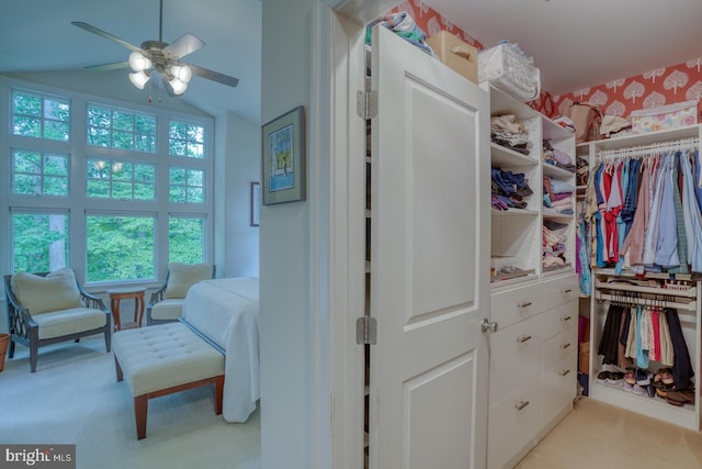 spacious closet featuring light carpet, vaulted ceiling, and ceiling fan