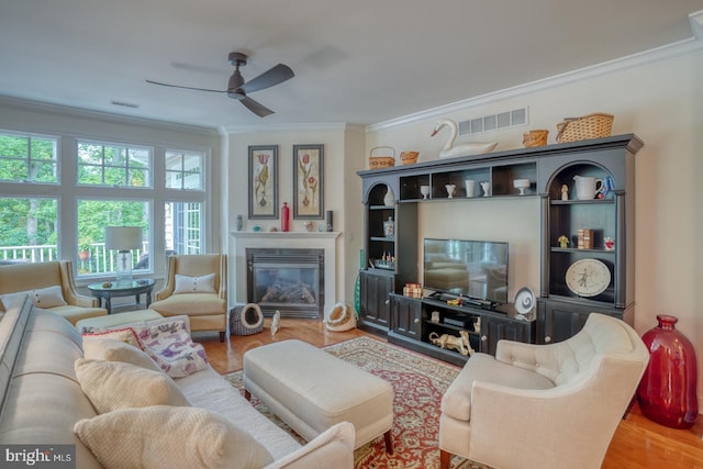 living room featuring crown molding, ceiling fan, and wood-type flooring