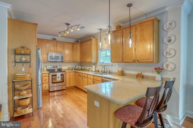 kitchen with kitchen peninsula, crown molding, stainless steel appliances, and decorative light fixtures