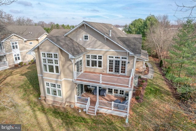 rear view of property featuring a lawn and a wooden deck