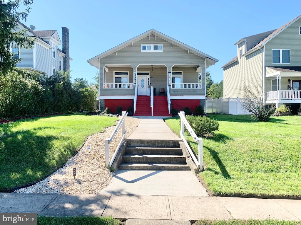 view of front of house with covered porch and a front lawn