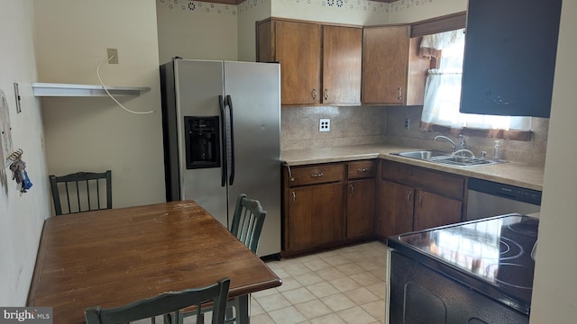 kitchen featuring decorative backsplash, sink, light tile patterned floors, and appliances with stainless steel finishes