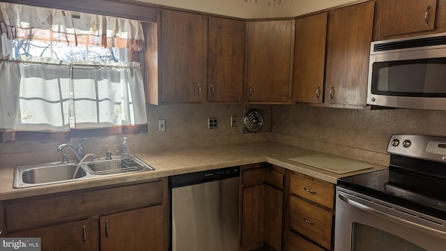 kitchen with backsplash, stainless steel appliances, a healthy amount of sunlight, and sink