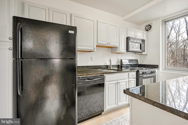 kitchen with sink, light tile patterned floors, black appliances, and white cabinets