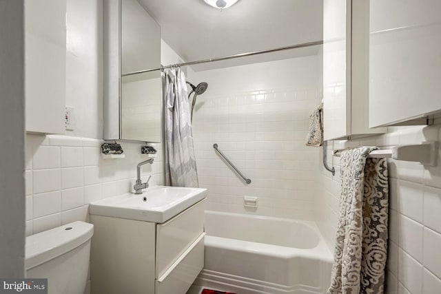 full bathroom featuring vanity, toilet, shower / tub combo, and tile walls