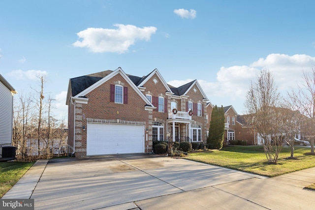 view of front of home featuring a front yard, a balcony, a garage, and central AC unit