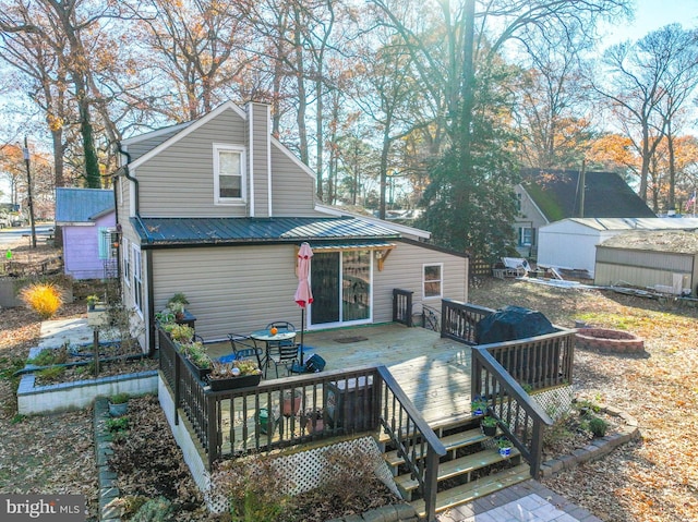 back of house featuring a wooden deck and an outdoor fire pit