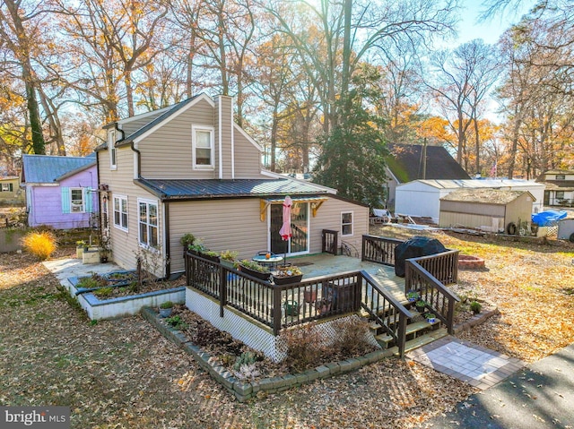 back of house featuring a deck and a shed