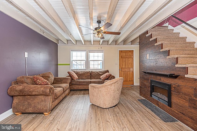 living room with hardwood / wood-style floors, a fireplace, beamed ceiling, and ceiling fan