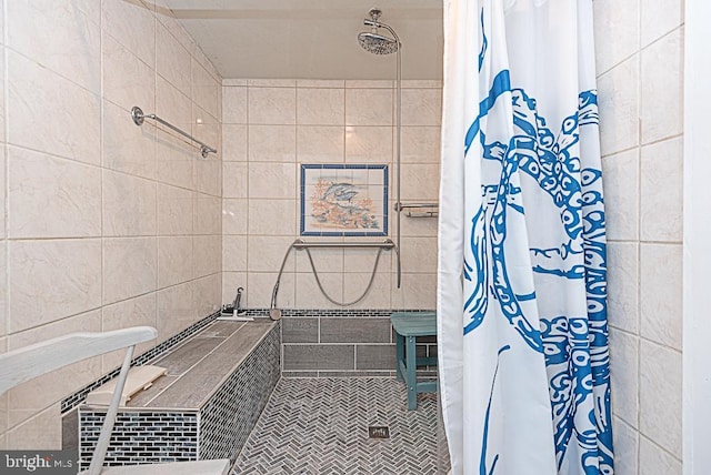 bathroom featuring tile patterned flooring, curtained shower, and tile walls