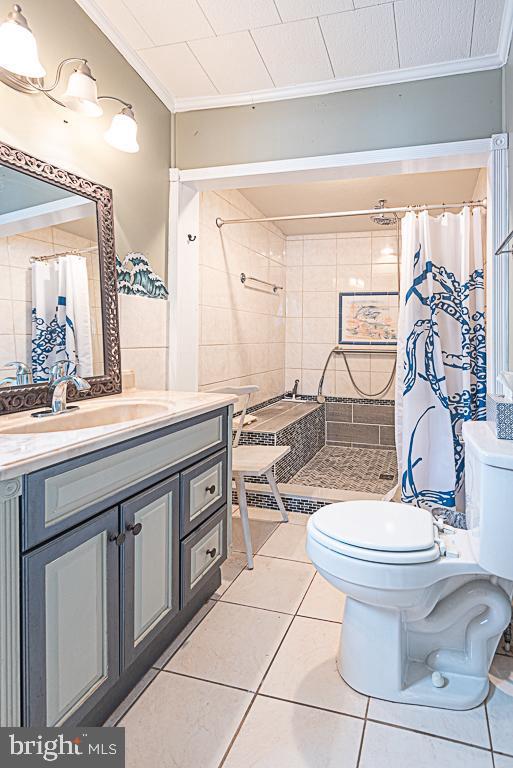 bathroom featuring walk in shower, ornamental molding, and tile patterned flooring